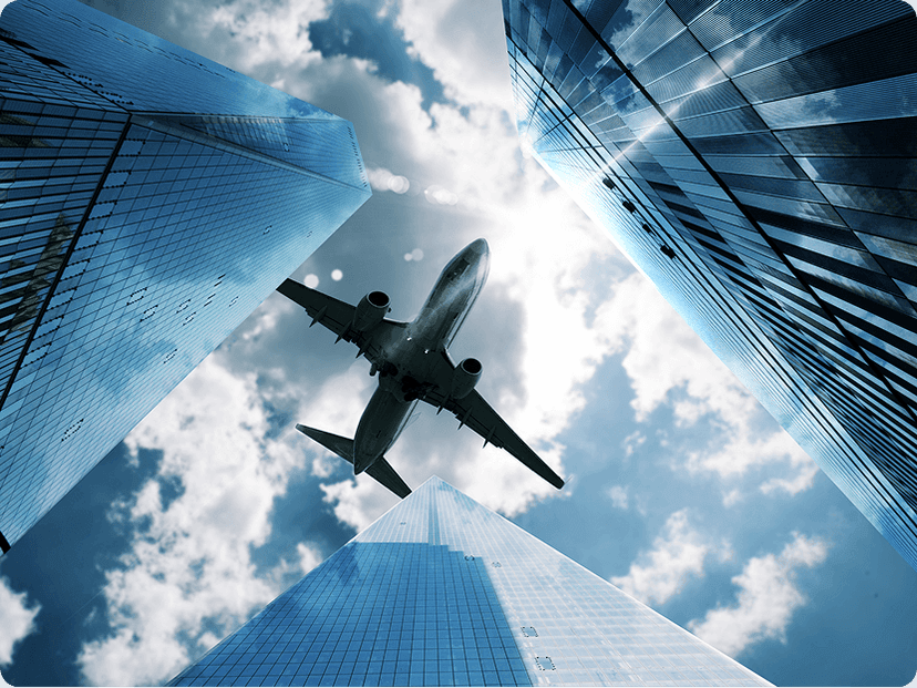 Airplane flying across buildings